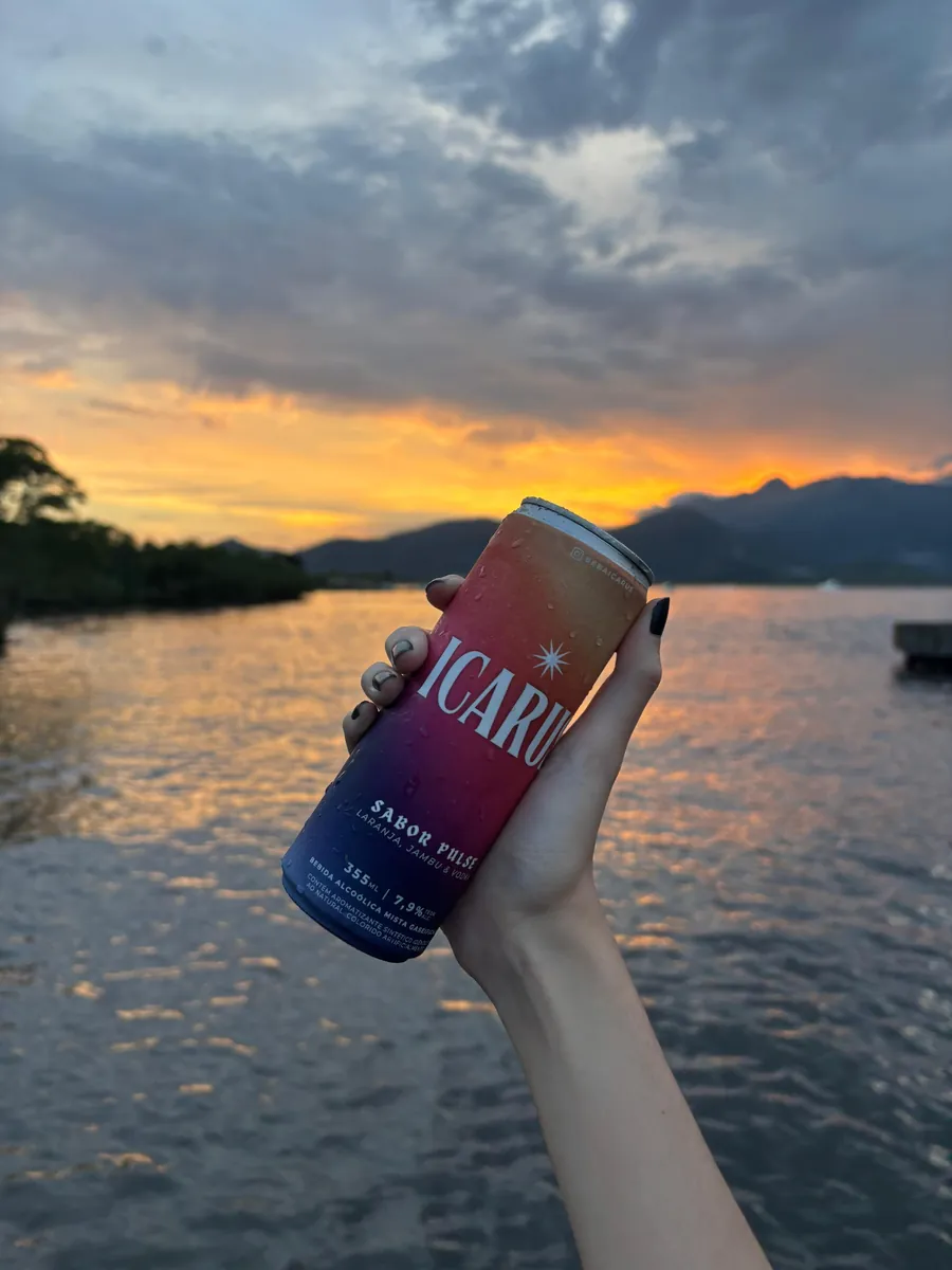 Lata de ICARUS erguida contra o pôr do sol, na beira d’água